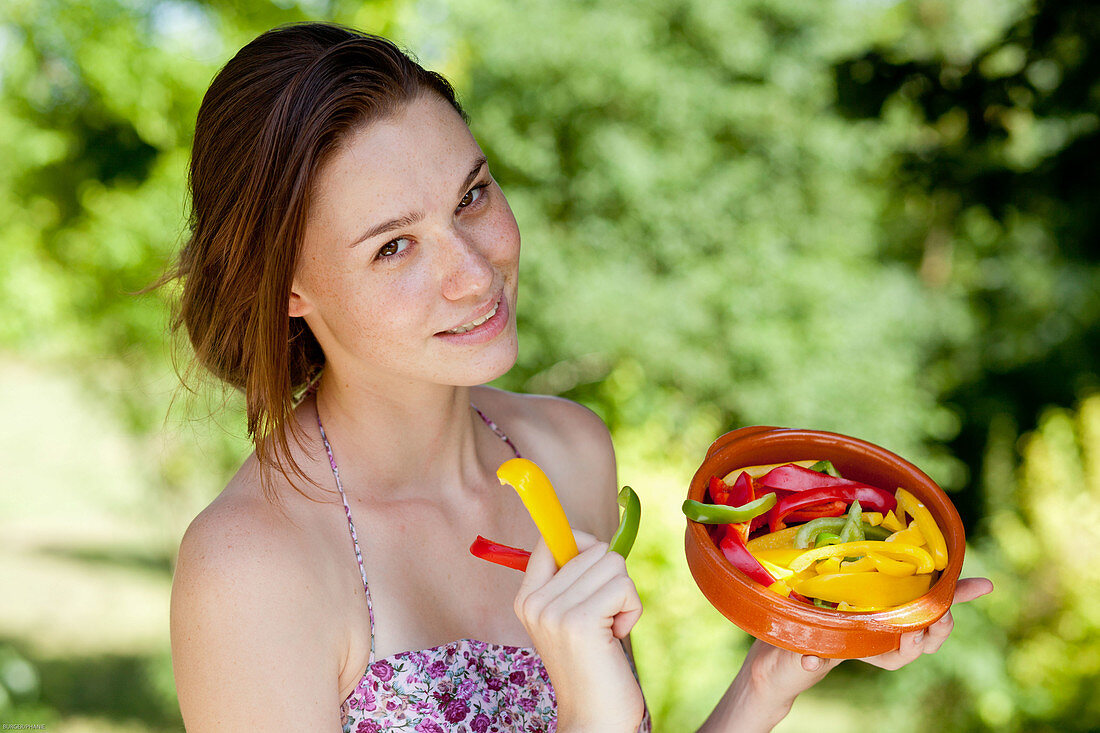 Woman eating a salad of bell peppers