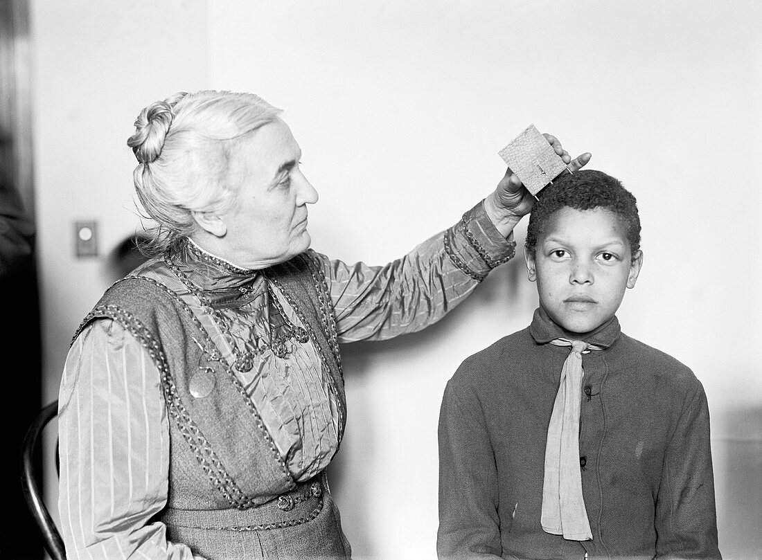 Doctor measuring skull curvature, 1914