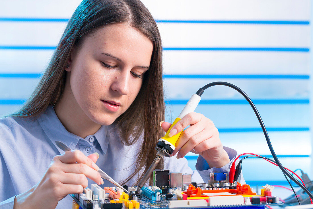 Young woman working on circuit board
