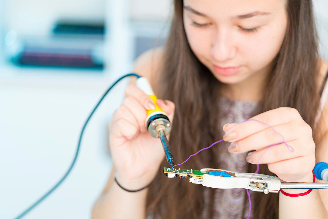 Girl using soldering iron