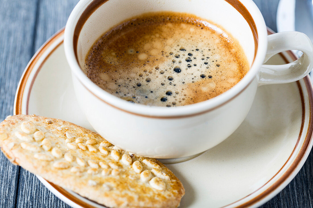 Espresso in coffee cup with biscuit