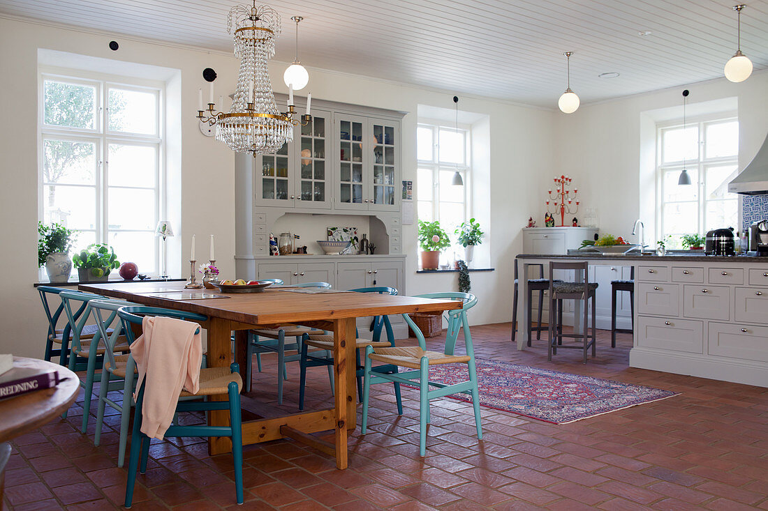 Dining table and blue designer chairs in country-house kitchen-dining room