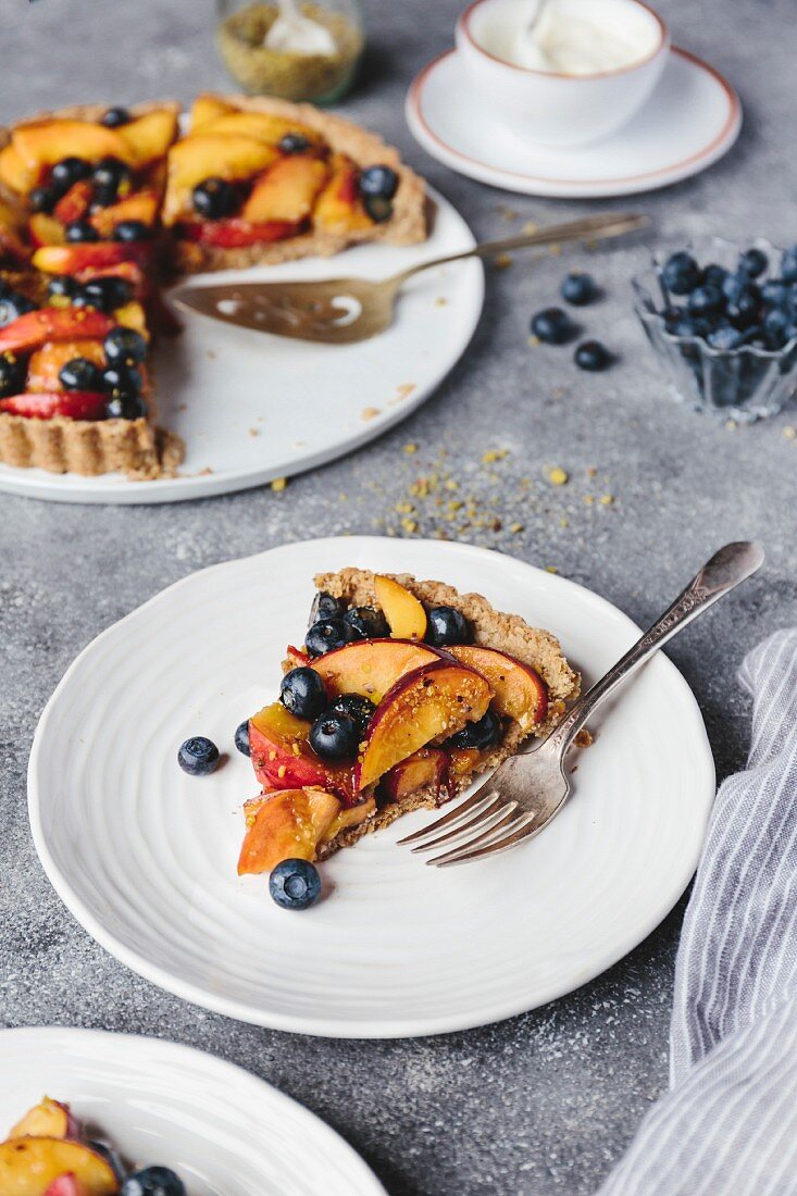 Pfirsich-Heidelbeeren-Tarte, ein Stück auf Teller