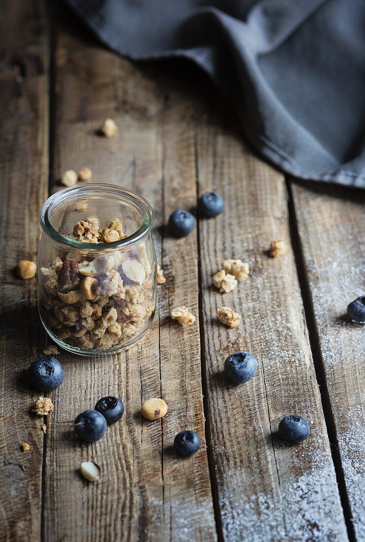 Muesli in a jar with blueberries on wooden table