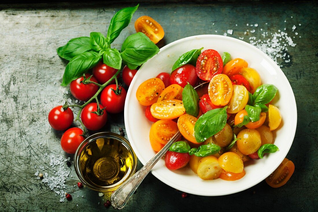 Tomatensalat mit verschiedenfarbigen Tomaten und Basilikum