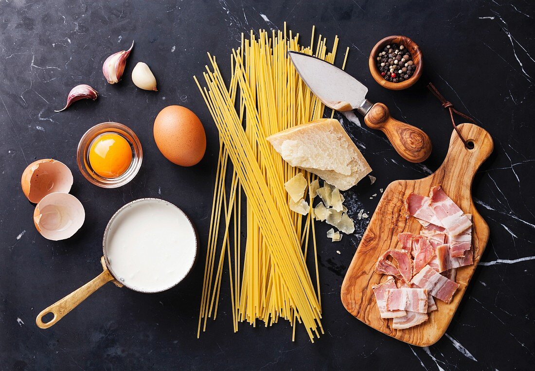 Ingredients for Pasta Carbonara on dark marble background