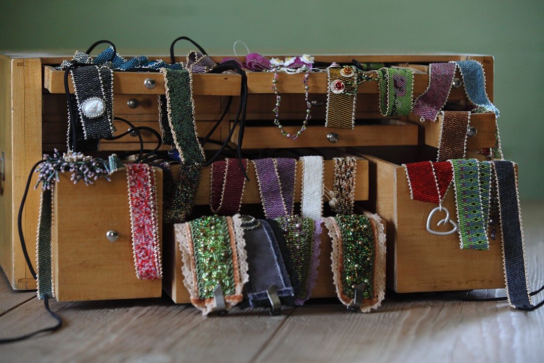 Hand-made glass-bead jewellery draped over jewellery box