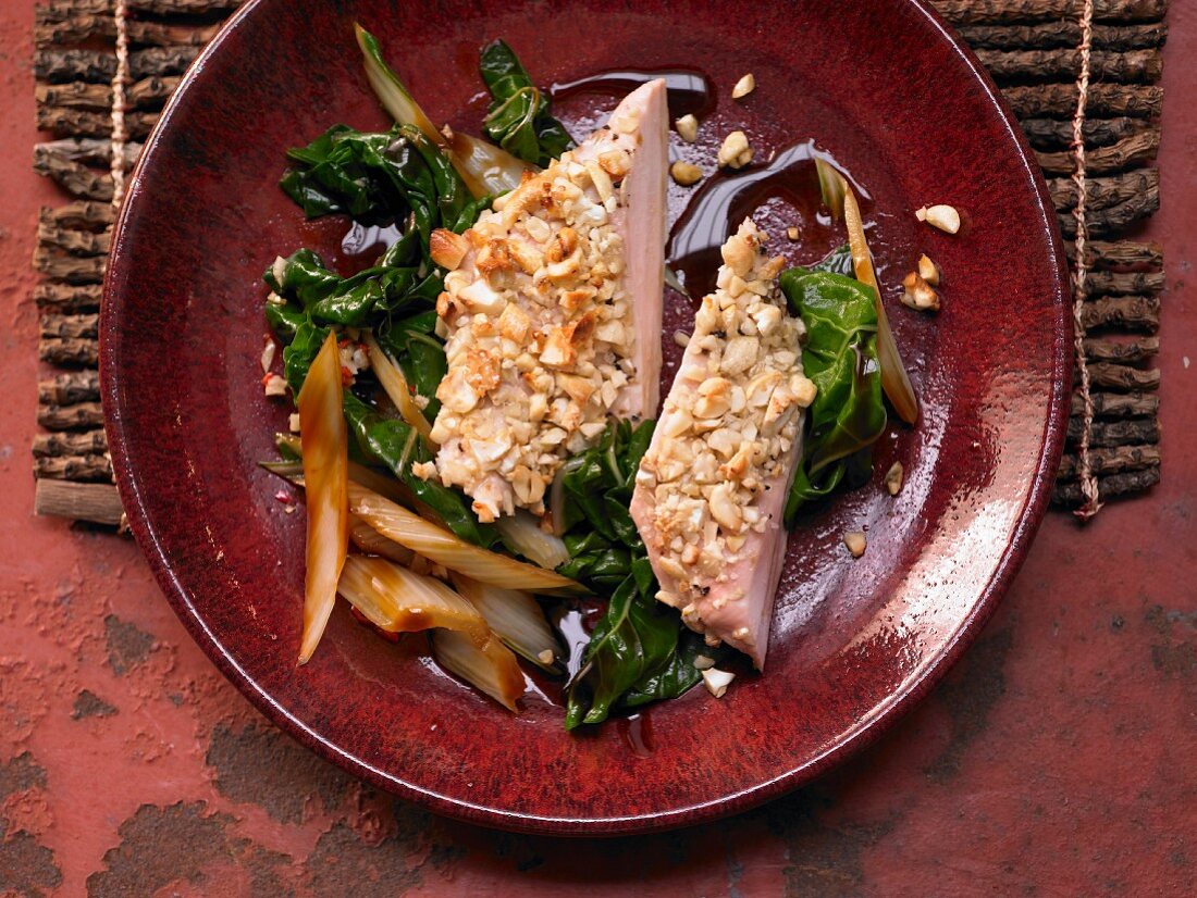Chicken breast with a cashew nut crust on spicy vegetables