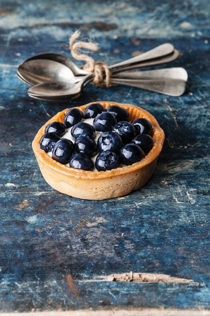 Blueberry tart on blue wooden background