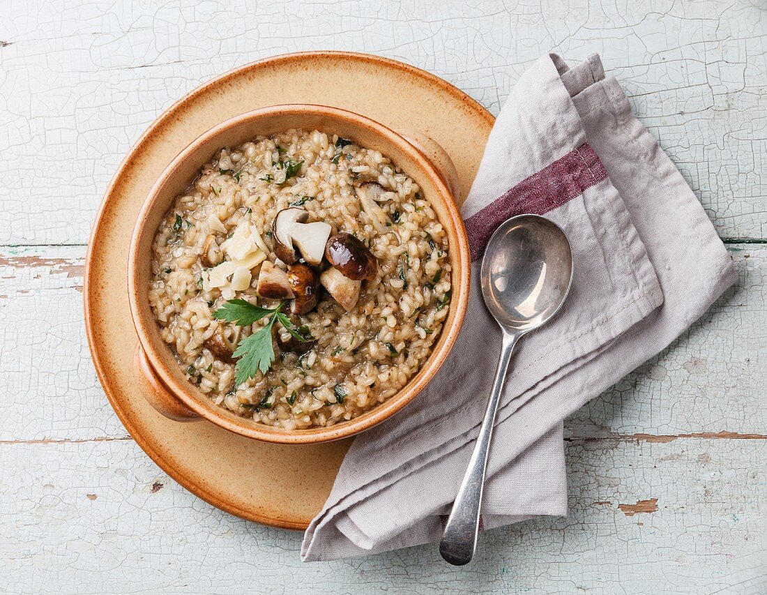 Risotto with wild mushrooms with parsley and parmesan on blue background