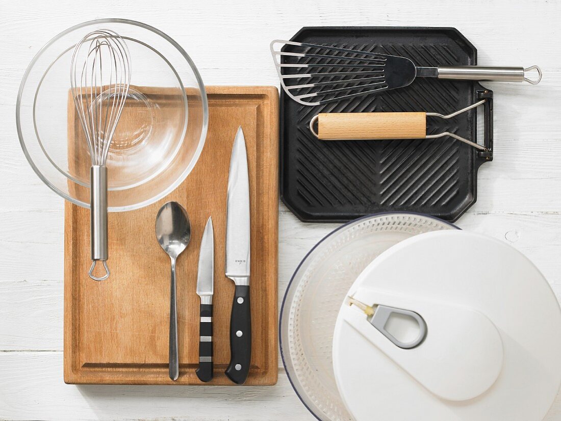 Various kitchen utensils: salad spinner, grill pan, spatula, knives, whisk