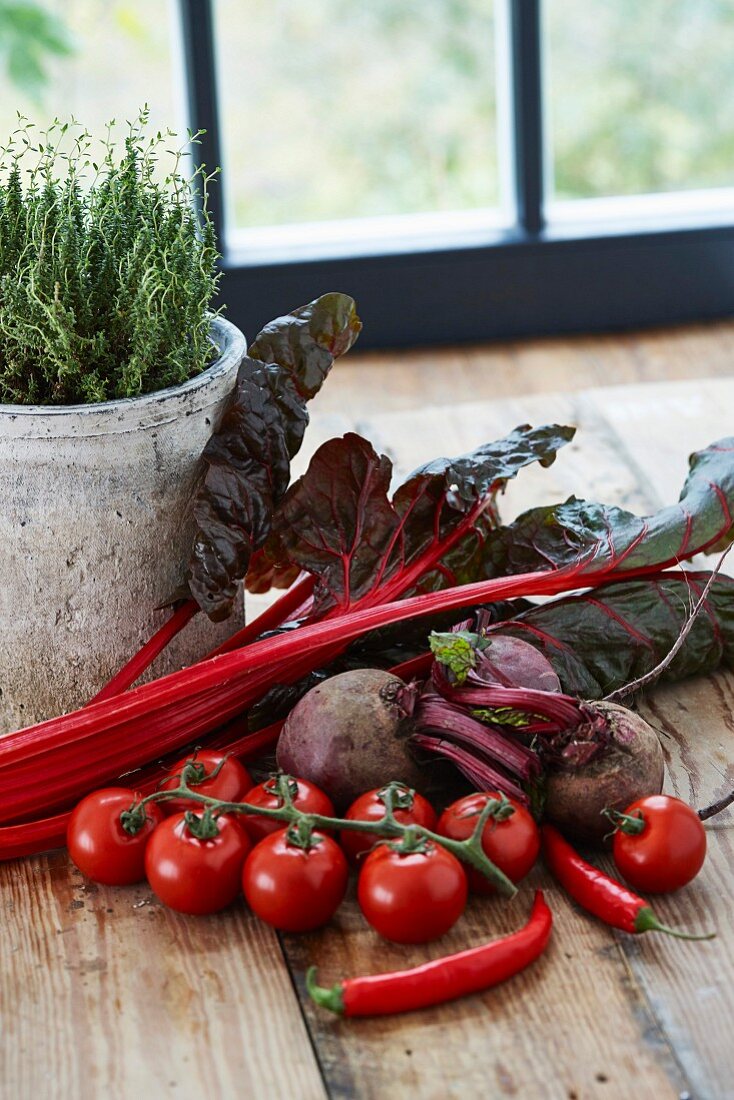 Red vegetables on a wooden table in front of a window