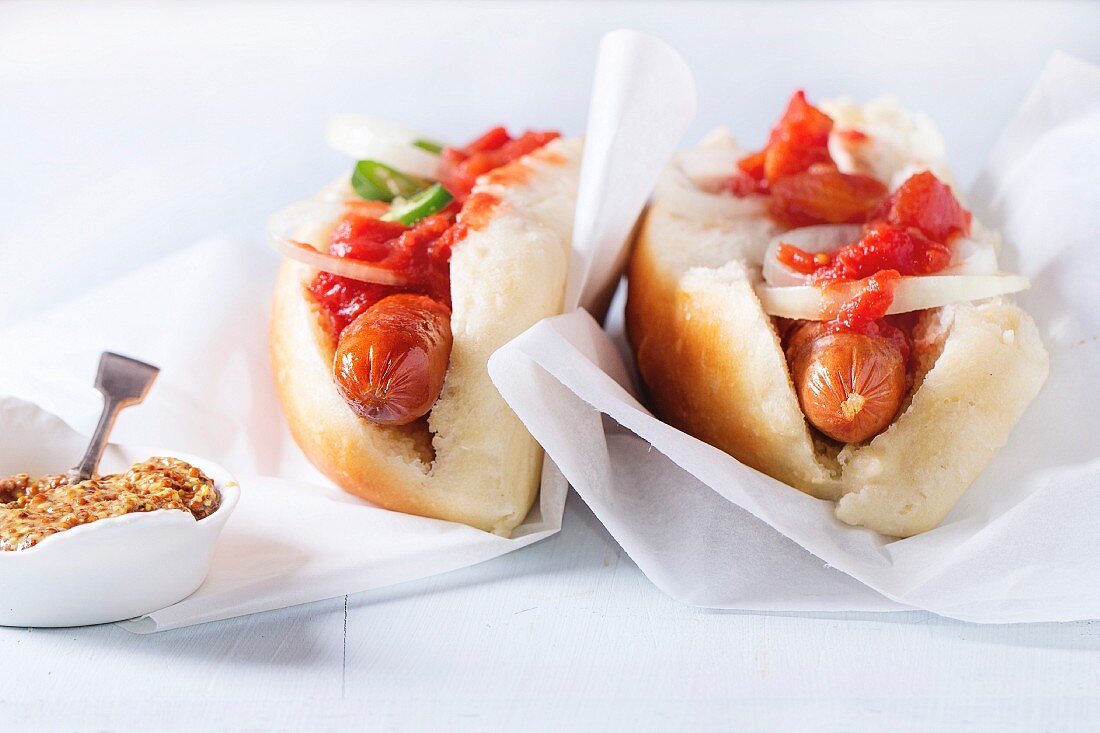 Selbstgemachte Hot Dogs mit Tomatensauce, Zwiebeln und Senf
