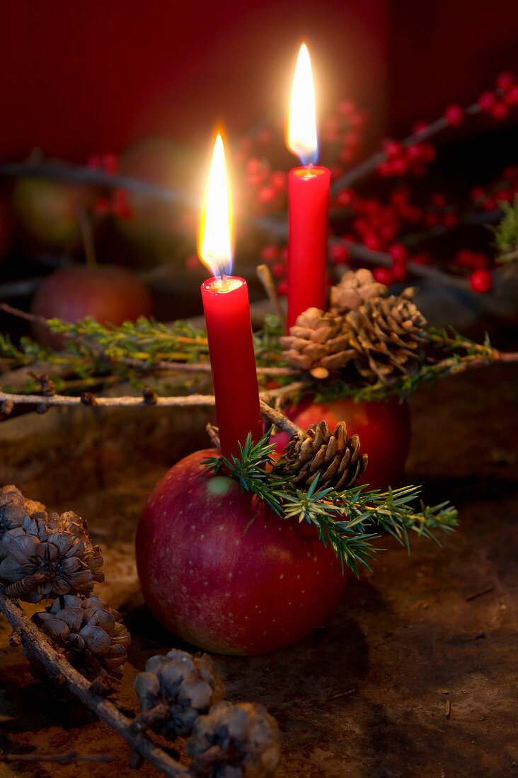 Apfel mit Kerze und Lärchenzweig als Weihnachtsdeko