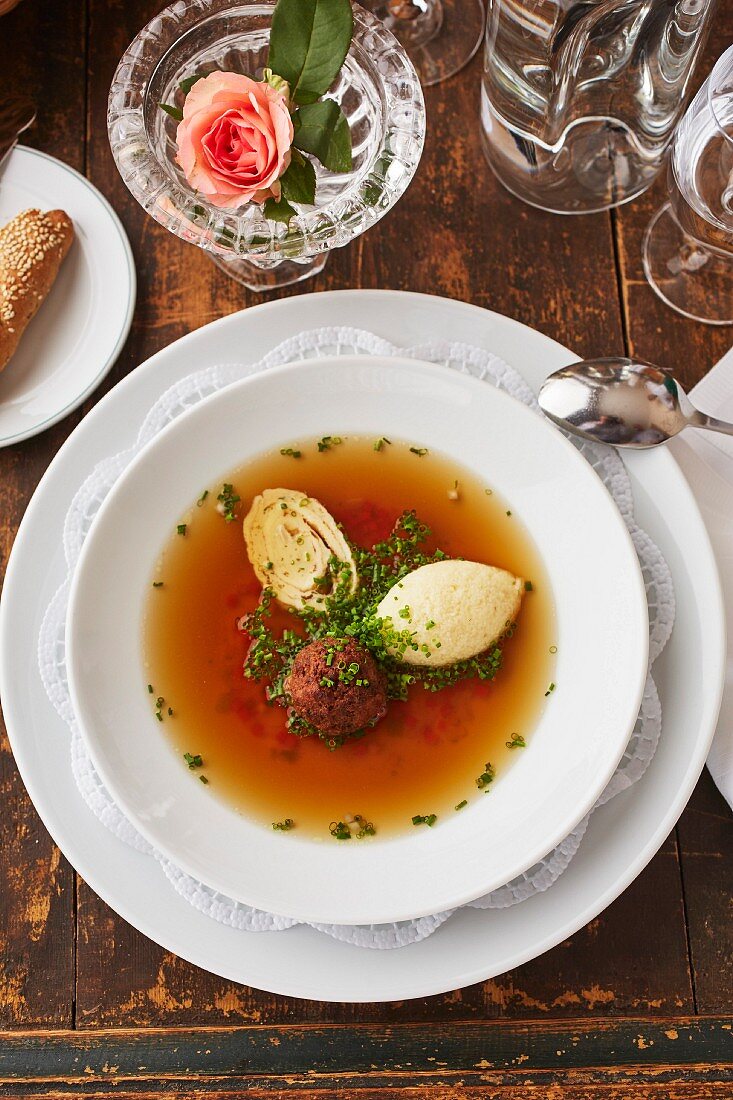 Beef broth with three different toppings: liver dumpling, semolina dumpling and a shredded pancake