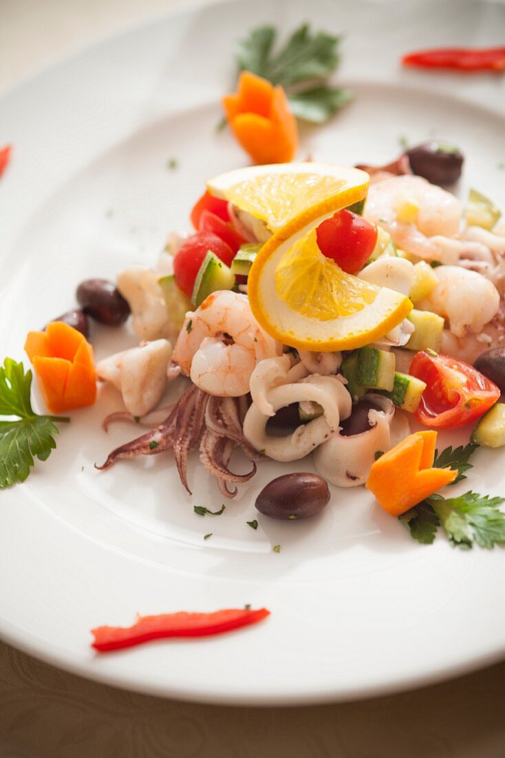 Meeresfrüchtesalat mit Tintenfisch, Garnelen, Zucchini, Oliven und Kirschtomaten