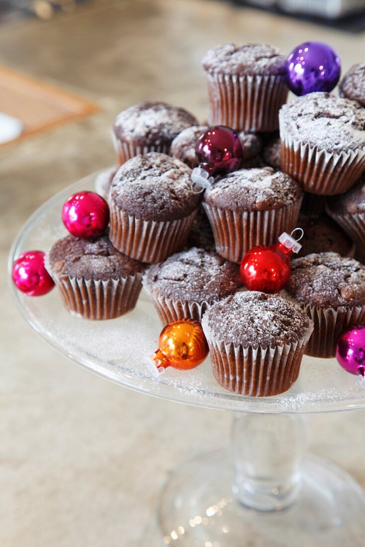 Muffins with Christmas baubles on a cake stand