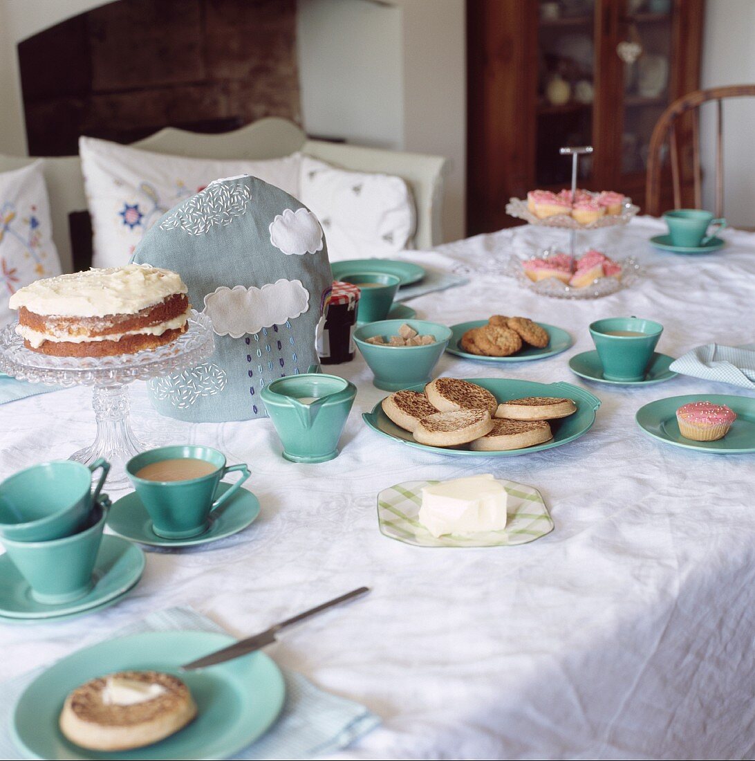 Gedeckter Tisch für den Nachmittagstee mit Crumpets und Kuchen