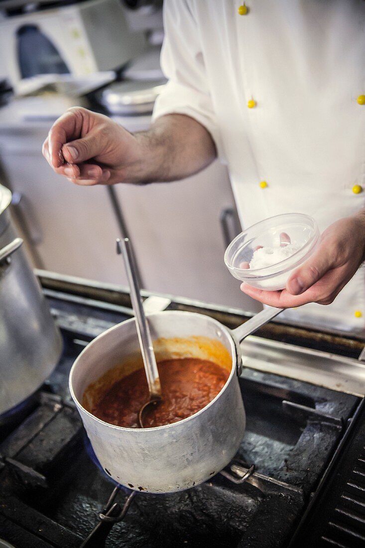 Koch salzt Tomatensauce