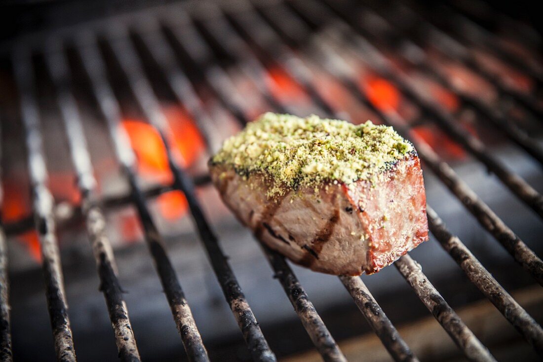 Tuna steak with a pistachio crust on a grill