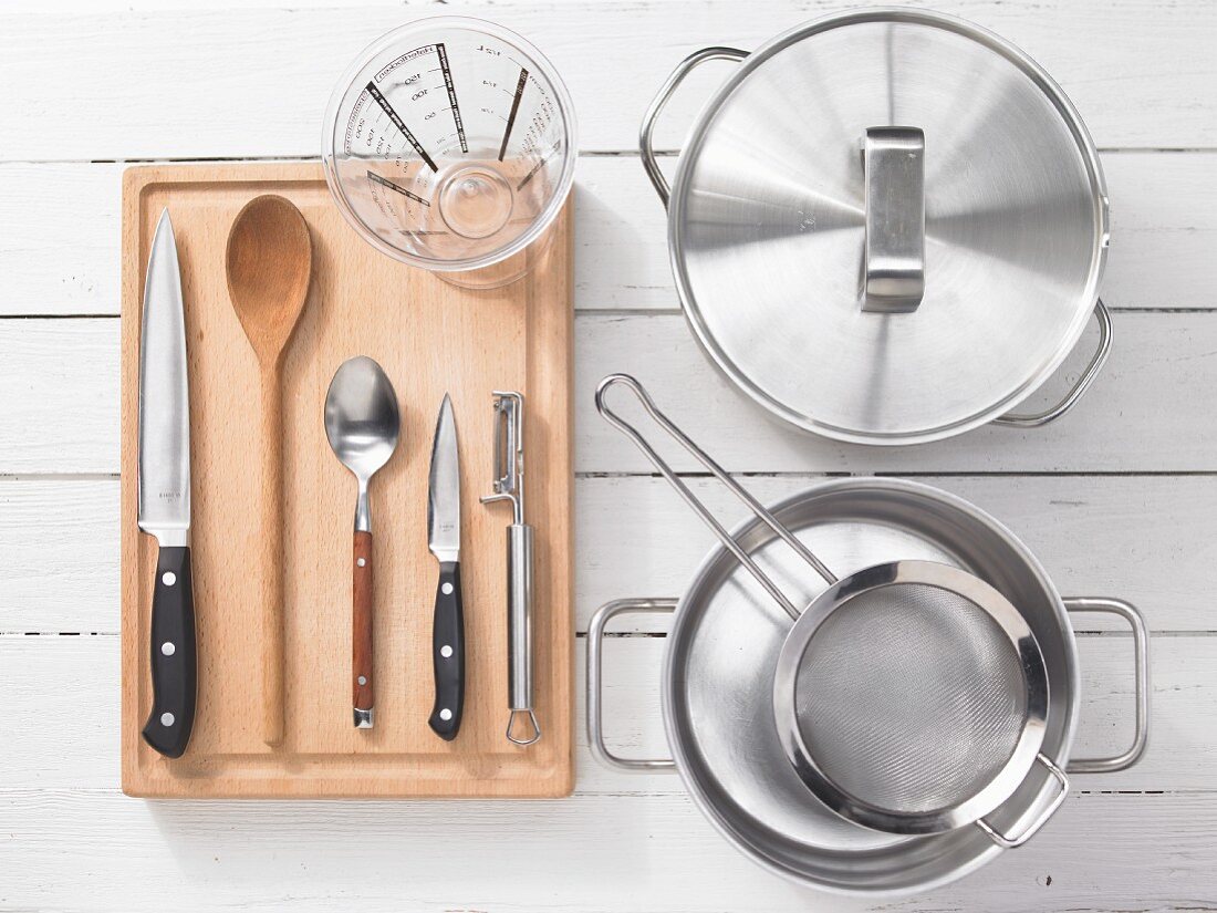 Various kitchen utensils: pots, sieves, measuring cups, knives, spoons