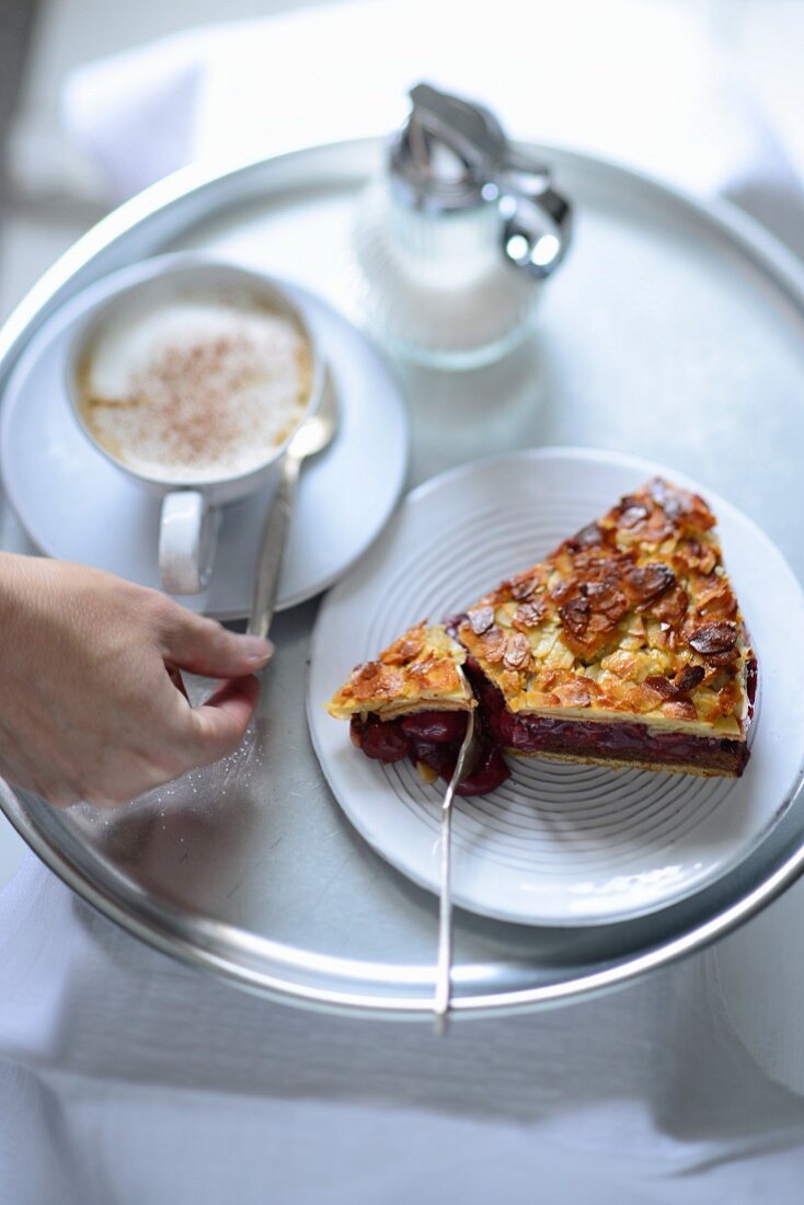A piece of cherry pie served with coffee