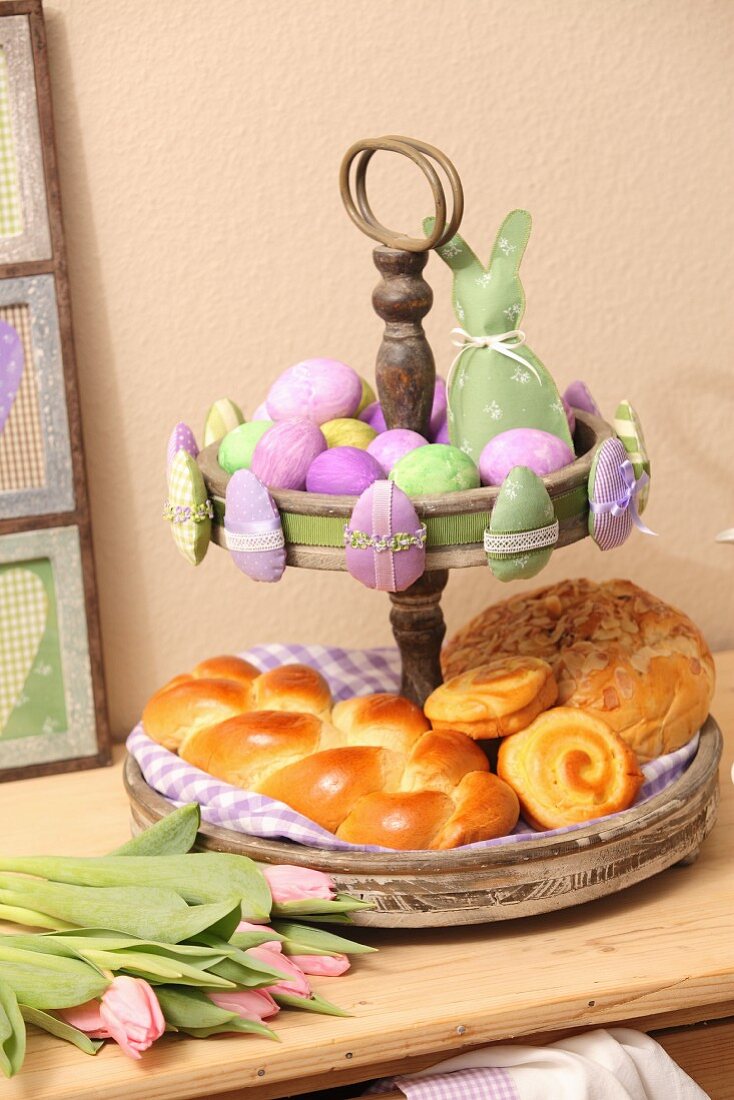 Pastries on vintage cake stand and green and lilac Easter ornaments