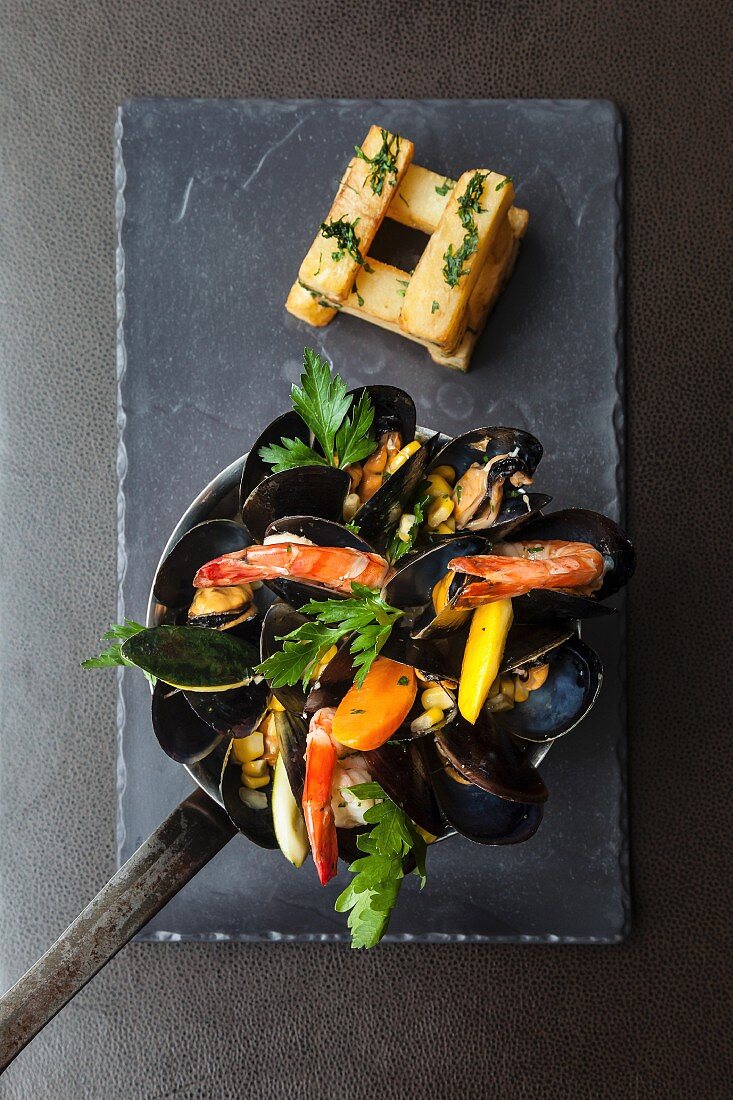 Muschelpfanne mit Garnelen, Mais, Gemüse und hausgemachten Chunky Chips