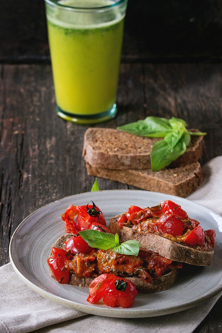 Bruschetta mit gebackenen Tomaten und Basilikum, dazu ein grüner Smoothie