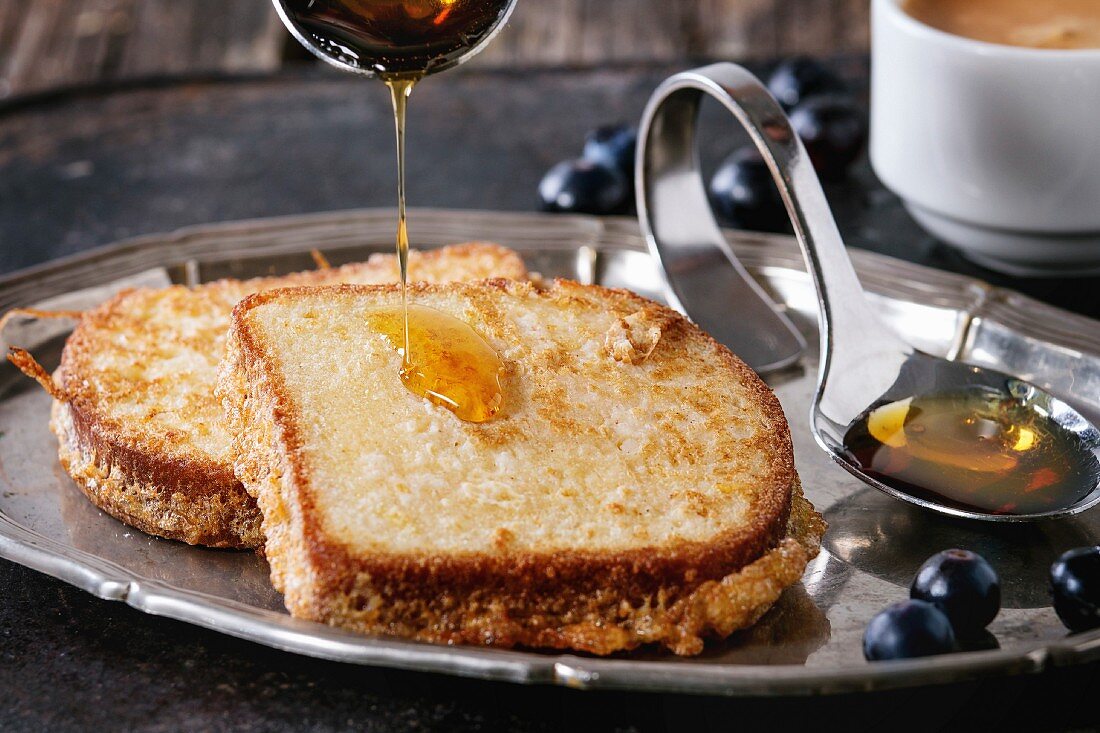 Gegrillter Toast mit Honig und Heidelbeeren auf Vintage-Tablett