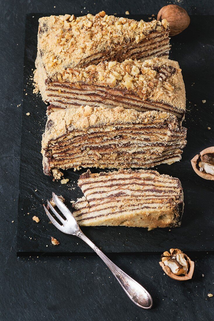 Sliced Homemade Honey Cake with chocolate cream and walnuts