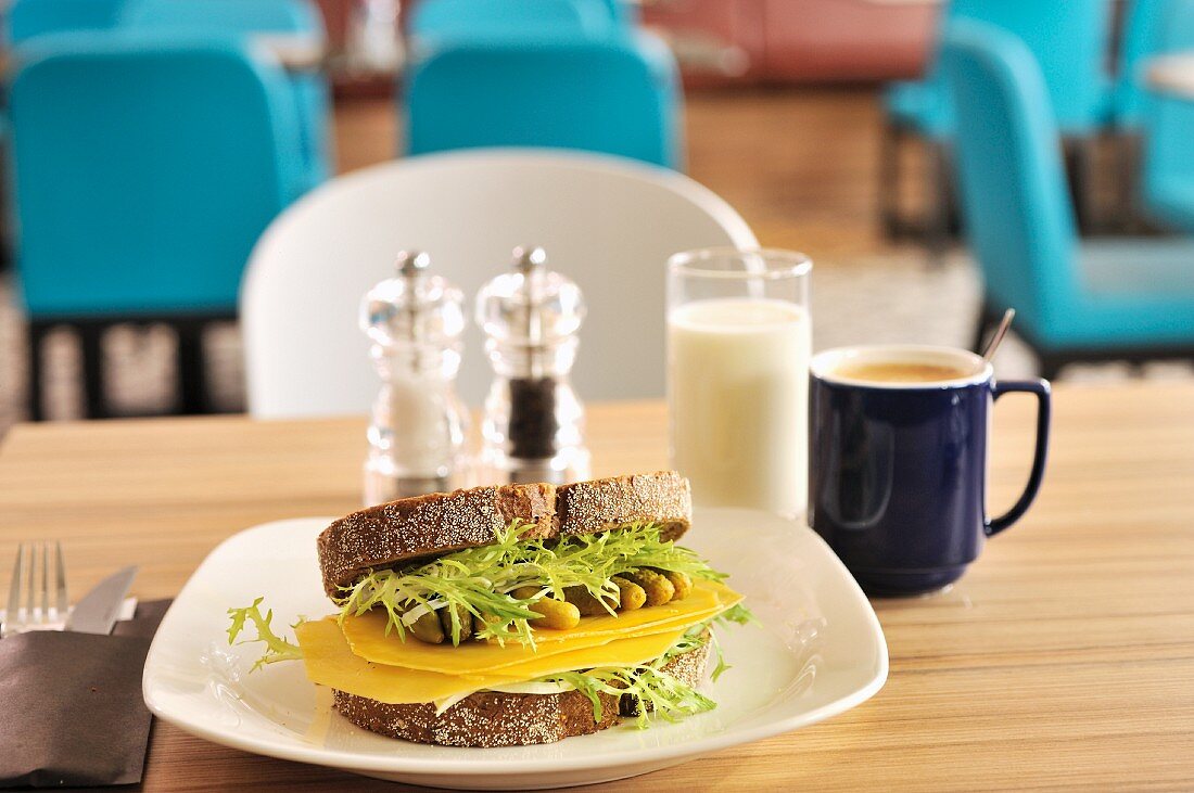 Old Dutch Käsesandwich mit Essiggurken und Salat, Kaffee und Glas Milch