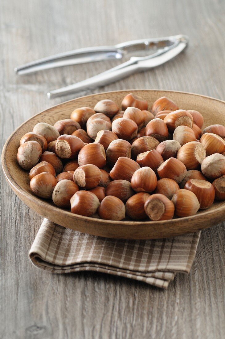 Hazelnuts in a wooden bowl with a nutcracker