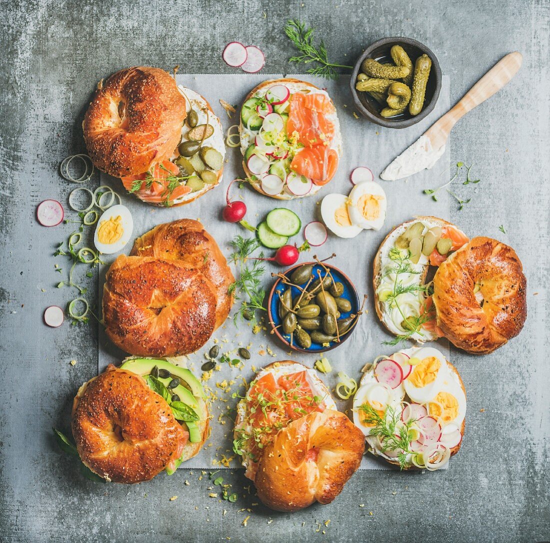 Verschiedene Bagel belegt mit Räucherlachs, Avocado, Ei Gemüse und Frischkäse