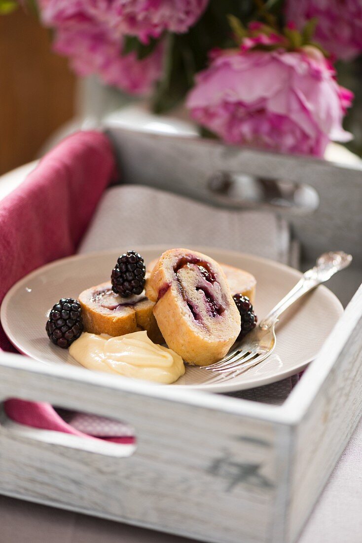 Sponge roll with blackberries and plums