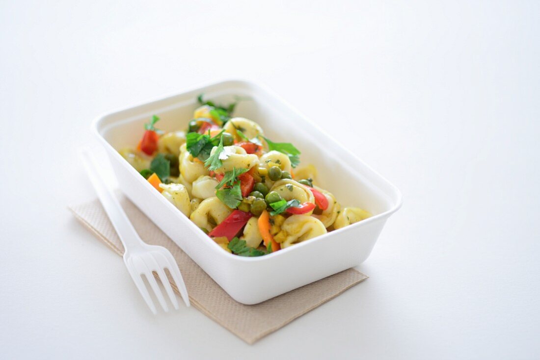 Tortellini with vegetables in a takeaway box