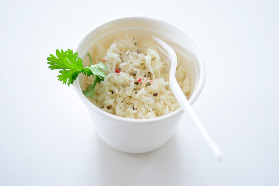 Rice with pepper and parsley in a takeaway pot