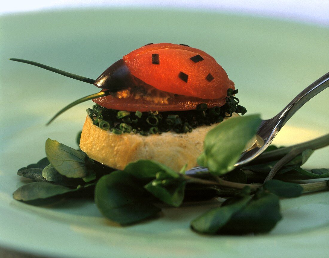 Tomato beetle with olive mousse on slice of white bread