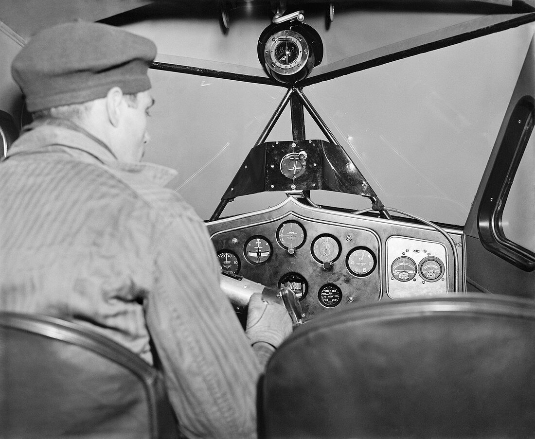 Pilot in cockpit with instrument landing system, 1937