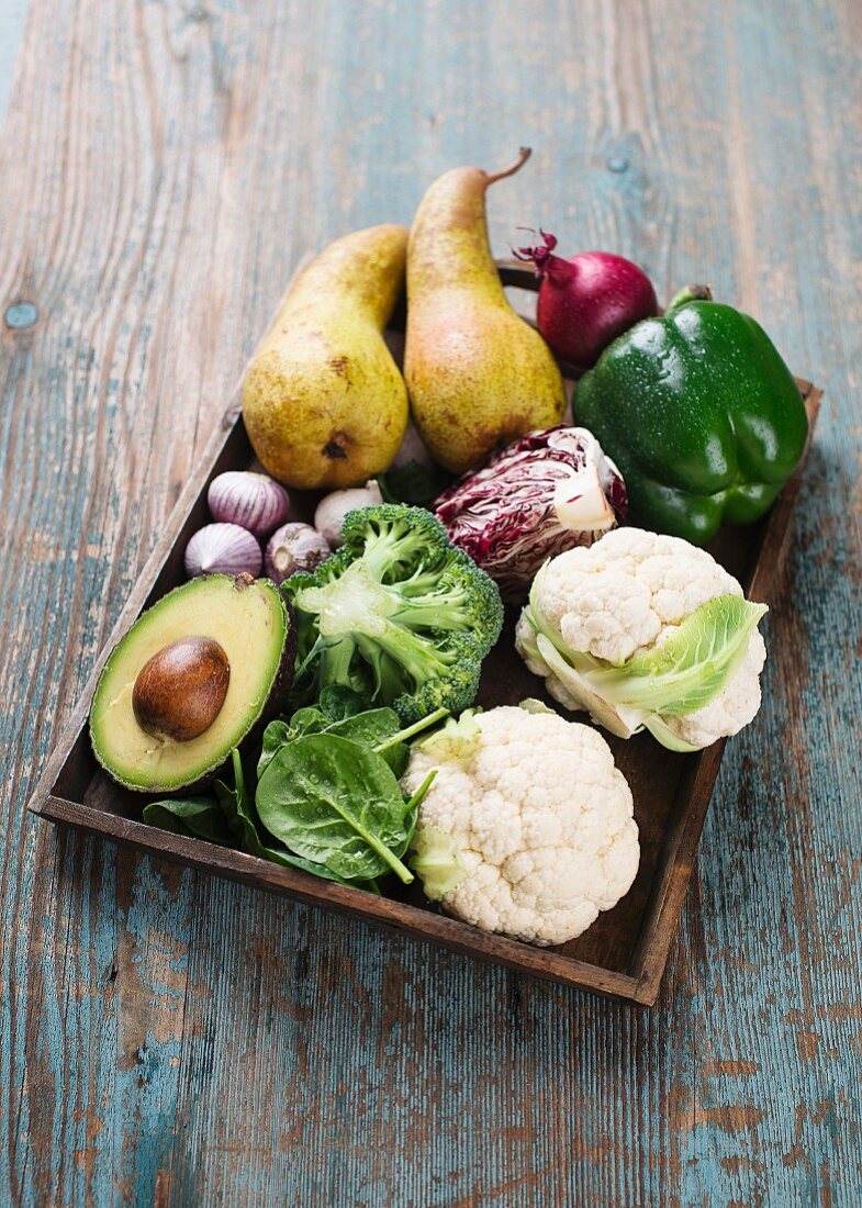 Various vegetables with pears on a wooden tray