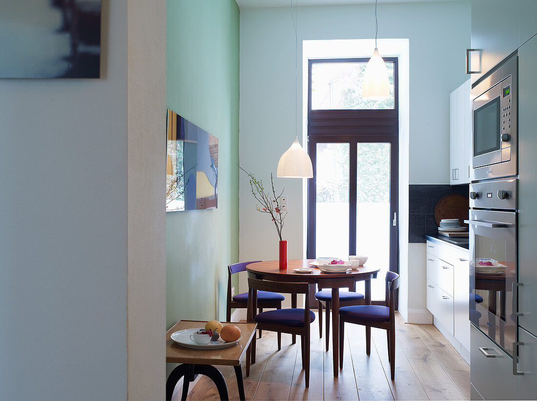 Dining table and three-legged chairs with triangular seat in kitchen