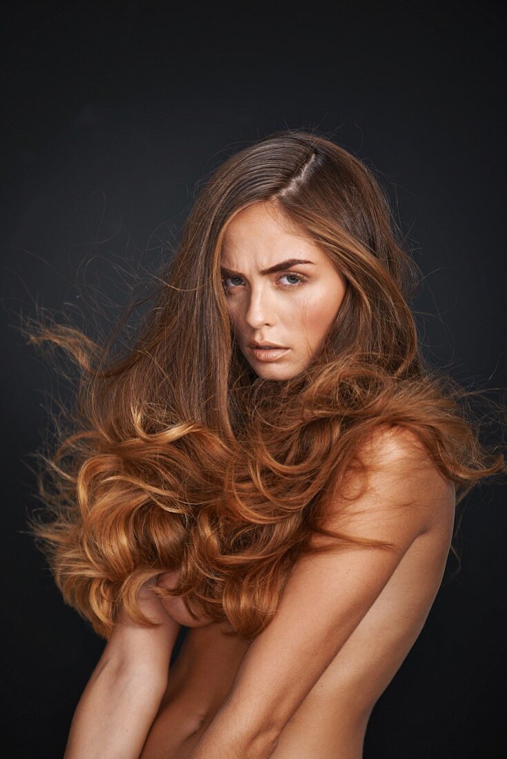 Nackte Frau mit lockigen, langen Haaren