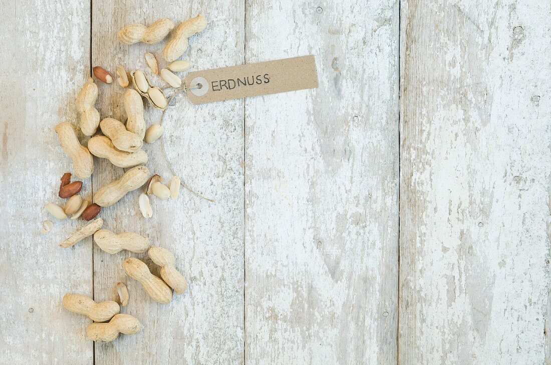 Erdnüsse mit Schildchen beschriftet auf Holzuntergrund (Aufsicht)