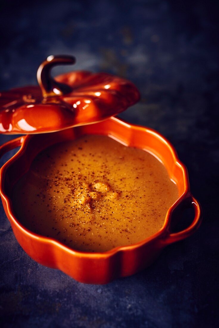 Butternut squash soup with chestnuts in an orange tureen