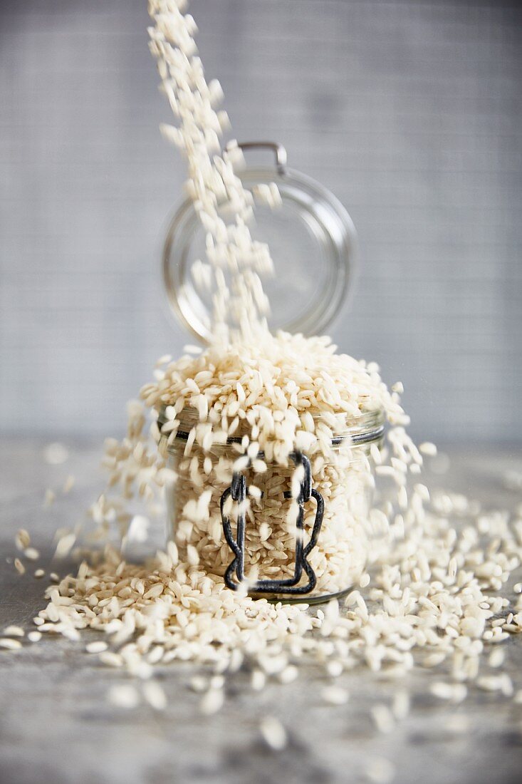 Risotto rice being poured into a flip-top jar