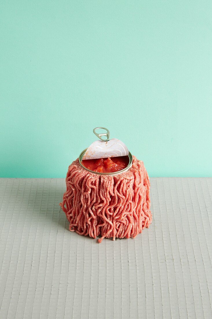 A symbolic image to represent minced beef sauce: a tin of tomatoes coated in raw minced beef
