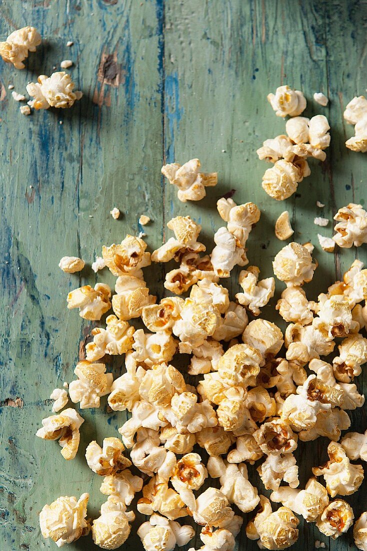 Popcorn covering an aqua blue green wooden surface