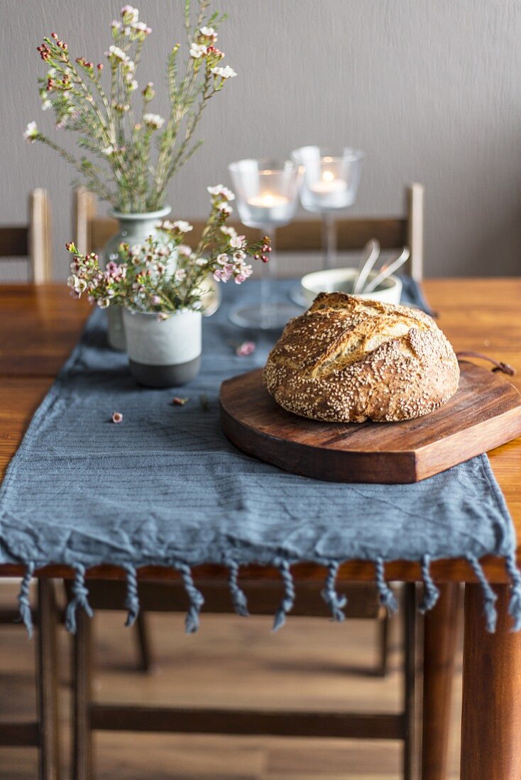 Bread and flowers on rustic wooden table