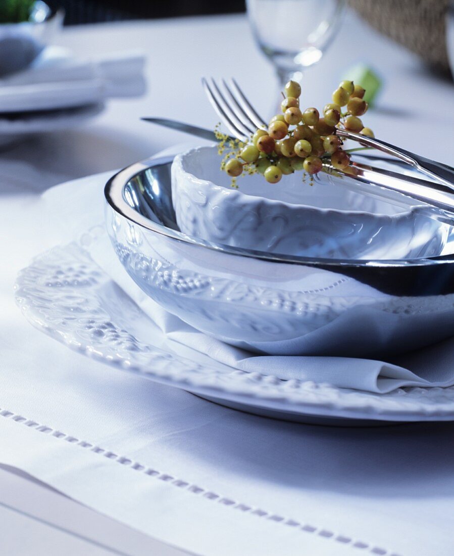 Festive place setting decorated with berries on white table mat