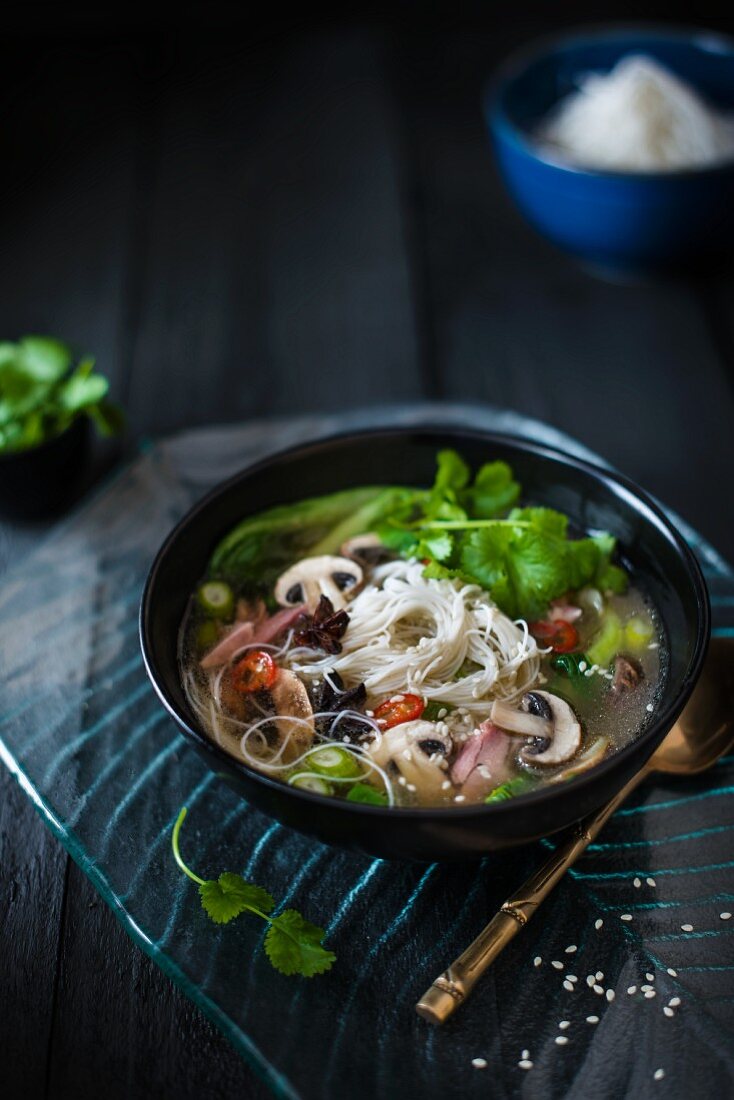 Oriental broth made with pork knuckle stock and meat with mushrooms, star anise, pak choi, chillis, sesame seed, miso with noodles